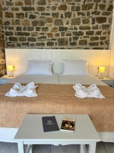 - un lit avec des draps blancs et une table avec un livre dans l'établissement Naiades Almiros Hotel, à Agios Nikolaos