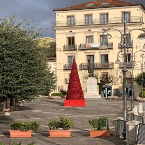a red tree in a parking lot in front of a building at L’Arco Bed&Breakfast in Avigliano