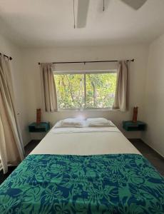een slaapkamer met een groot bed en een raam bij Casa Mariposa in Tola