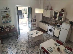 a kitchen with a refrigerator and a table and a microwave at La Mulasciara, Scilla in Scilla