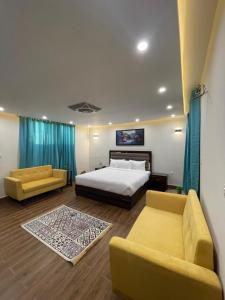a bedroom with a bed and two couches at Hamdan Hotel and Resort in Murree