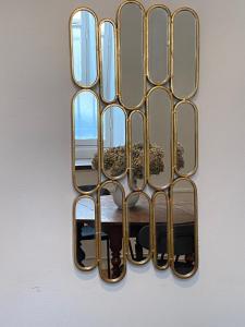 a gold mirror hanging on a wall at Grand studio style bordelais dans le triangle d'or in Bordeaux
