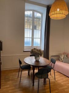 a living room with a table and chairs and a window at Grand studio style bordelais dans le triangle d'or in Bordeaux