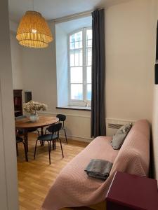 a room with a bed and a table and a window at Grand studio style bordelais dans le triangle d'or in Bordeaux