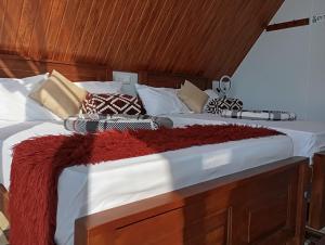 a large bed with white sheets and pillows on it at Dedunu Cabana & Resort in Badulla