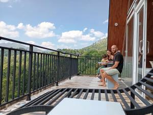 eine Familie sitzt auf dem Balkon eines Hauses in der Unterkunft Dedunu Cabana & Resort in Badulla + 1 Foto