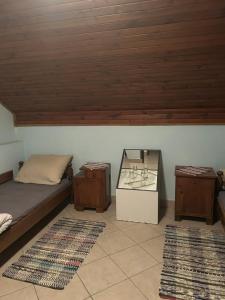 a bedroom with a bed and two tables and two rugs at B&B Lukač in Kutina +46 photos