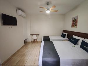 a bedroom with two beds and a flat screen tv at Nuevo Bamboo in Piura