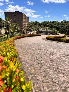 a cobblestone walkway in a park with flowers at Gran Lençóis Flat Residence Barreirinhas - Mandacaru 211 in Barreirinhas