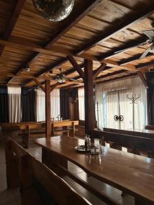 a dining room with a large wooden table and windows at B&B Lukač in Kutina