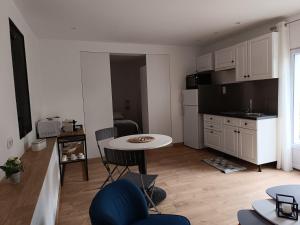 a living room with a table and a kitchen at Charmant T2 au calme in Vidauban