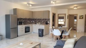 a kitchen and living room with a table and chairs at Flat 1 Central Apartment in Swieqi in Is-Swieqi