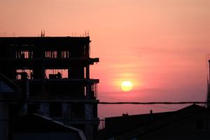 una silueta de un edificio con la puesta de sol en el fondo en Da! Hostel en Bishkek