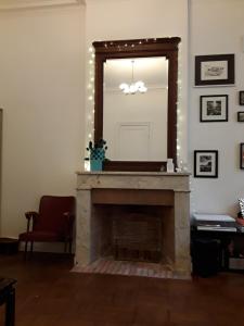 a living room with a fireplace with a mirror at Grand studio style bordelais dans le triangle d'or in Bordeaux