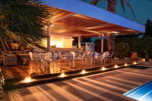 a patio with chairs and a table with lights at Danae Hotel in Egina