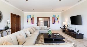 a living room with a white couch and a tv at Casa Ceylan Luxury 8 Bed Villa with Sea, Golf & Mountain Views in Sotogrande