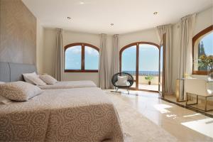 a bedroom with two beds and a view of the ocean at Casa Ceylan Luxury 8 Bed Villa with Sea, Golf & Mountain Views in Sotogrande +25 photos