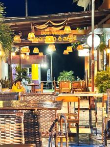 a restaurant with tables and chairs at night at Gran Lençóis Flat Residence Barreirinhas - Mandacaru 211 in Barreirinhas