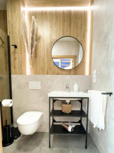 ein Bad mit einem Waschbecken und einem Spiegel in der Unterkunft Między Wodami in Międzywodzie