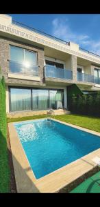 a swimming pool in front of a house at فلل التن تاج ALTINTAC villalari in Sapanca