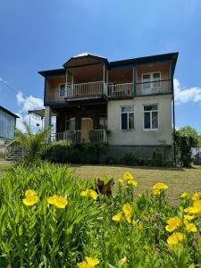 una casa con flores amarillas delante de ella en Guesthouse SANIKO, en Martvili