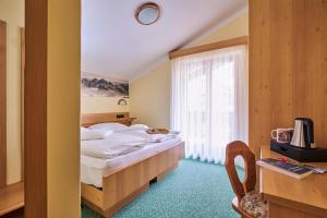 a hotel room with a bed and a window at Berg Hotel Latemar Spitze in Vigo di Fassa