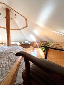a attic room with a bed and a chair at Ziedu pirts in Auciems