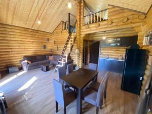 una sala de estar con mesa y sillas en una cabaña en Wood house Halkidiki, en Nea Fokea
