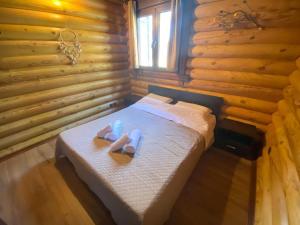 a bedroom with a bed with two slippers on it at Wood house Halkidiki in Nea Fokea