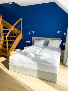Bett in einem Zimmer mit blauer Wand in der Unterkunft Między Wodami in Międzywodzie