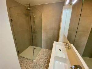 een badkamer met een douche en een wastafel bij Beach Suite Leonie Koksijde met zeezicht in Koksijde +14 foto's