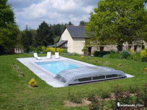 a swimming pool in the yard of a house at Chambres d'Hôtes Logis de l'Etang de l'Aune in Iffendic
