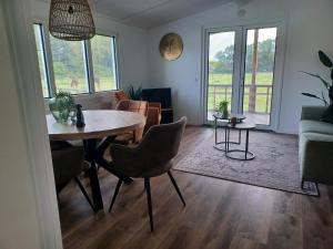 a living room with a table and chairs at IJsvogel in Schipborg