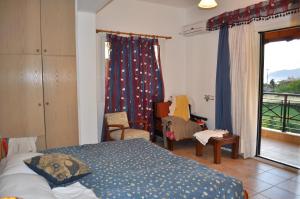 ein Schlafzimmer mit einem Bett und einem Balkon in der Unterkunft Holiday House Litsa 50 metres from Agios Gordios Beach in Agios Gordios