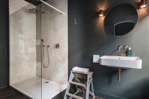 W łazience znajduje się prysznic, umywalka i lustro. w obiekcie The Bank 1869 - Unique guestrooms in the historic center of Bruges w Brugii