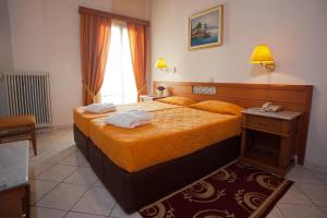 a bedroom with a bed with two towels on it at Acropole Delphi City Hotel in Delphi