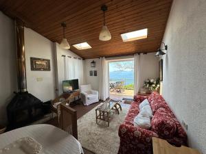 Casas 1ª línea ría de Vigo في فيغو: غرفة معيشة مع أريكة وإطلالة على المحيط