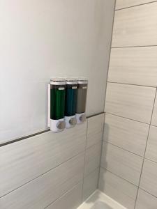 a row of green and white cups in a bathroom at 2 Bedroom House & Parking 2 washrooms in Reading
