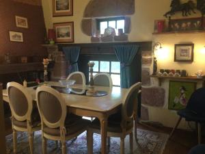 uma sala de jantar com uma mesa de madeira e cadeiras em Maison luxe Collonges la rouge,jakuzzi,clim,WIFI,piscine em Collonges-la-Rouge