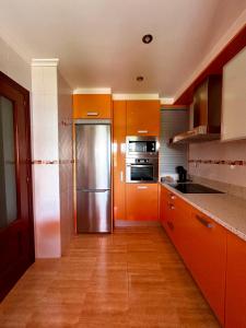 a kitchen with orange cabinets and a stainless steel refrigerator at HOLYDAY HOME SUANCES in Suances