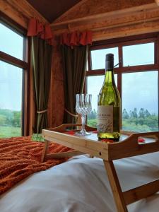 een fles wijn en een glas op een tafel in een slaapkamer bij Little Oakhurst in Clitheroe
