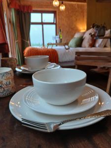 une table avec deux bols blancs et des assiettes dessus dans l'établissement Little Oakhurst, à Clitheroe