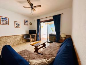een woonkamer met een blauwe bank en een tafel bij Quiet Coral Mar in Arona