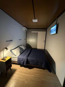 a bedroom with a bed and a tv on the wall at Hotel In Box in Irati