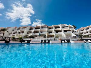 um hotel com piscina em frente a um edifício em Quiet Coral Mar em Arona