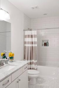 a white bathroom with a toilet and a shower at NEW Music Icon House in East Nashville in Nashville +32 photos
