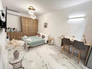 een woonkamer met een bed en een tafel en stoelen bij Corfu Airport Sweet Studio in Ágios Rókkos