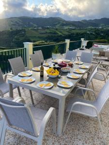 a white table with chairs and food on it at Vista do Topo in Povoação