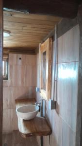 La salle de bains est pourvue d'un lavabo et d'un bol sur le mur. dans l'établissement Cabaña La Fortaleza Villa Yacanto, à Villa Yacanto