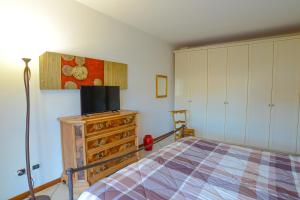 a bedroom with a bed and a tv on a dresser at Casa Milena - VADOALMARE Immobiliare in Vado Ligure